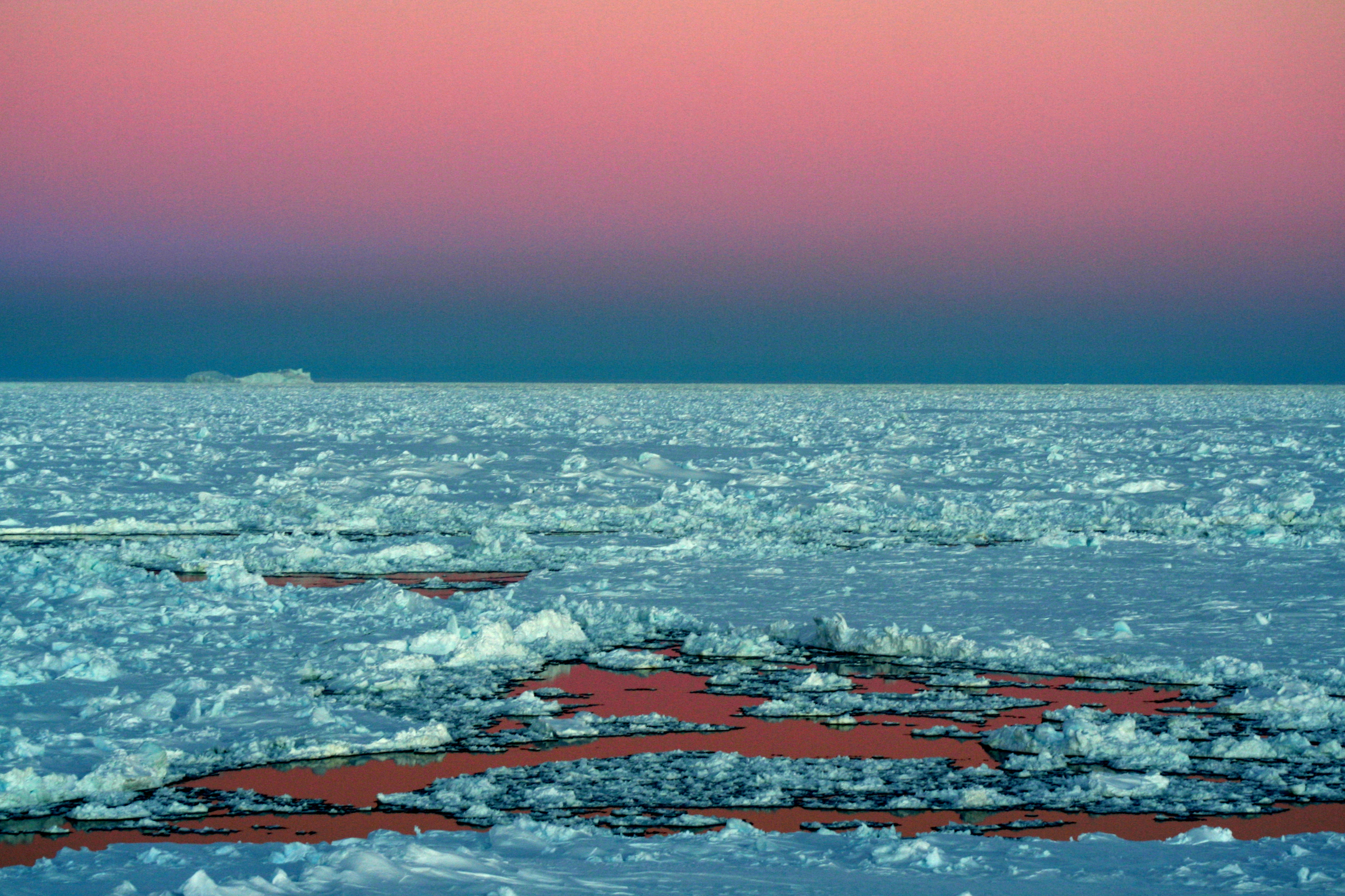 Photo BANQUISE : Lumière crépusculaire en mer de Weddell (Antarctique). Tel un lac de lave solidifiée flottant sur un magma liquide, la banquise se disloque, se fissure et se fragmente, laissant l’océan s’infiltrer dans les moindres ouvertures.